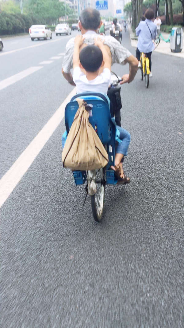 下班骑共享单车回家路上看到爷爷吃力的拖着孙子,孙子也觉得爷爷累,帮