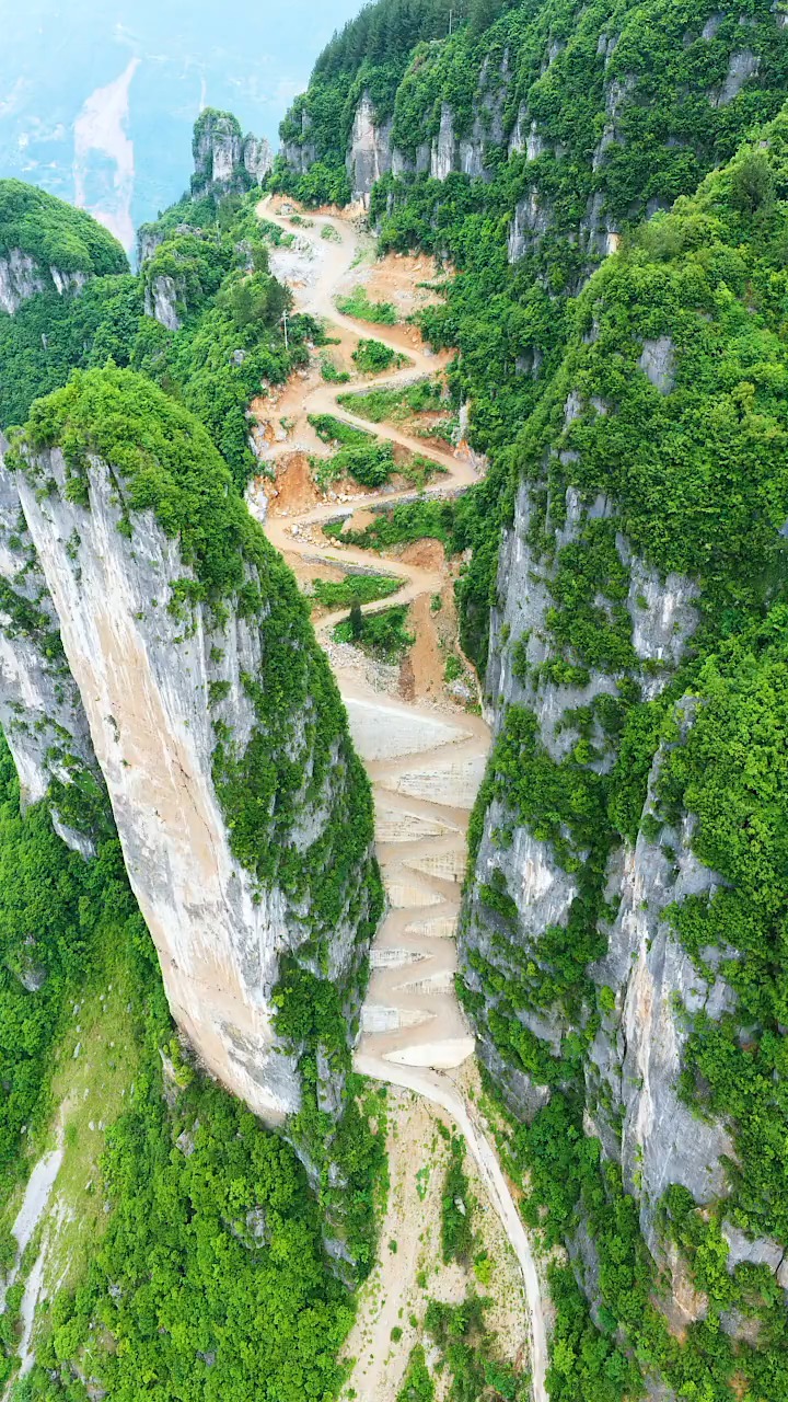 县一条修在大山凹槽中的盘山路,历时3年,一公里的路就有30多个回头弯