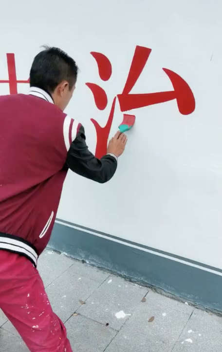 大叔在墙上写字,哈,书法高手在民间