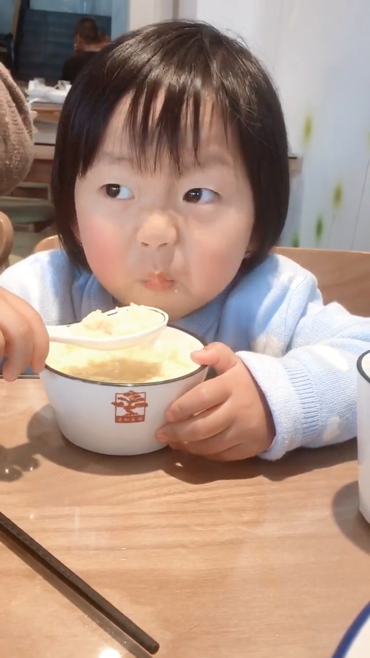 小女孩吃饭吃的好认真,看着好可爱!