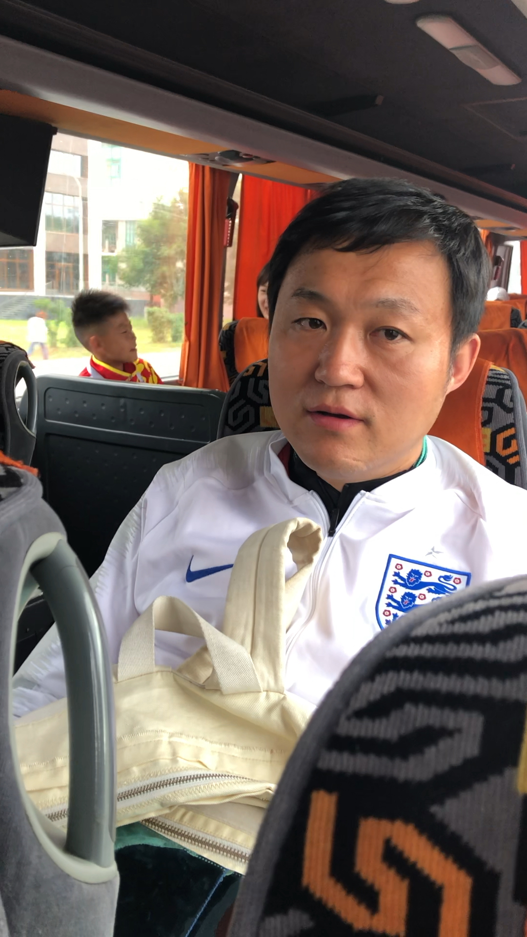 号报道团在【踢球吧少年强】前往比赛现场的大巴上采访央视名嘴王涛